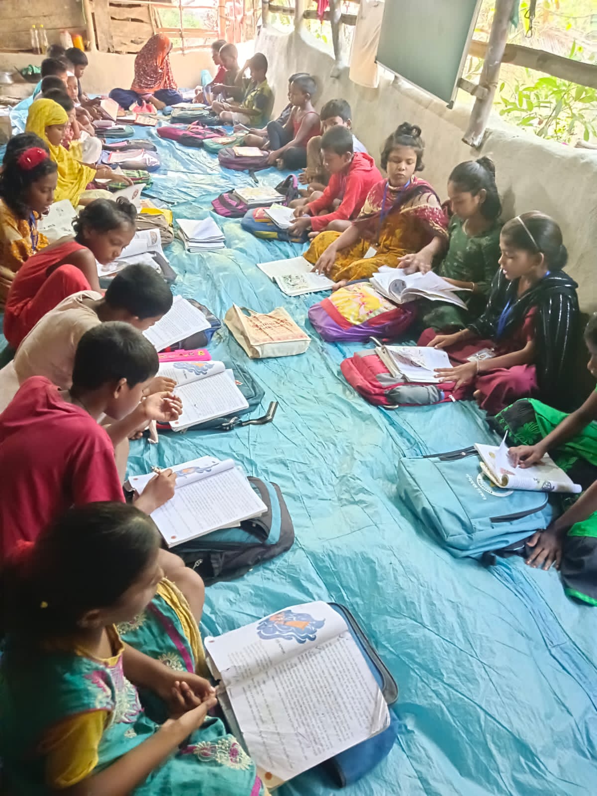 Children sitting on mats studying together with books